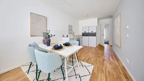 Wohnzimmer und Küche des Musterhauses in UP TOWN Houses mit Blick auf den Flur.