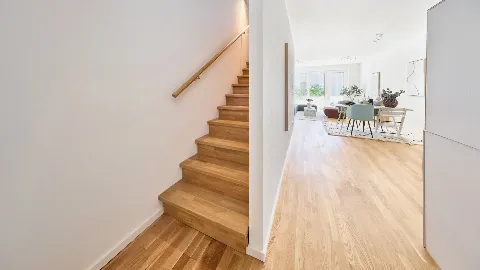 Treppe in die nächste Etage des Musterhauses in UP TOWN Houses. Im Hintergrund das Wohnzimmer.