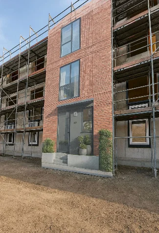 Am Gerüst des Rohbaus ist eine Plane mit der Visualisierung eines Townhouses angebracht.