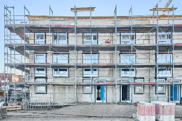 Foto des Rohbaus mit den eingebauten Fenstern der Townhouses in der Frontalansicht.